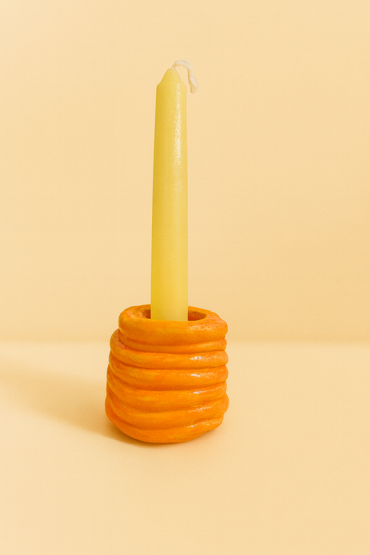 Handmade orange ribbed coil candle holder designed for taper candles, styled as modern aesthetic table decor