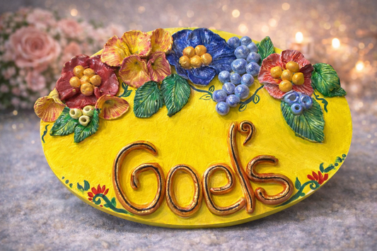 Handmade personalized floral clay family name plate mounted on home entrance wall with custom surname and decorative flowers