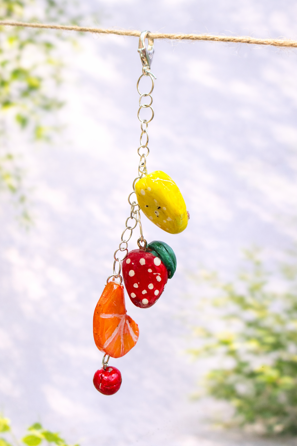 Handmade kawaii fruit charm keychain cluster featuring miniature mango, strawberry, orange and cherry clay charms attached to a keyring